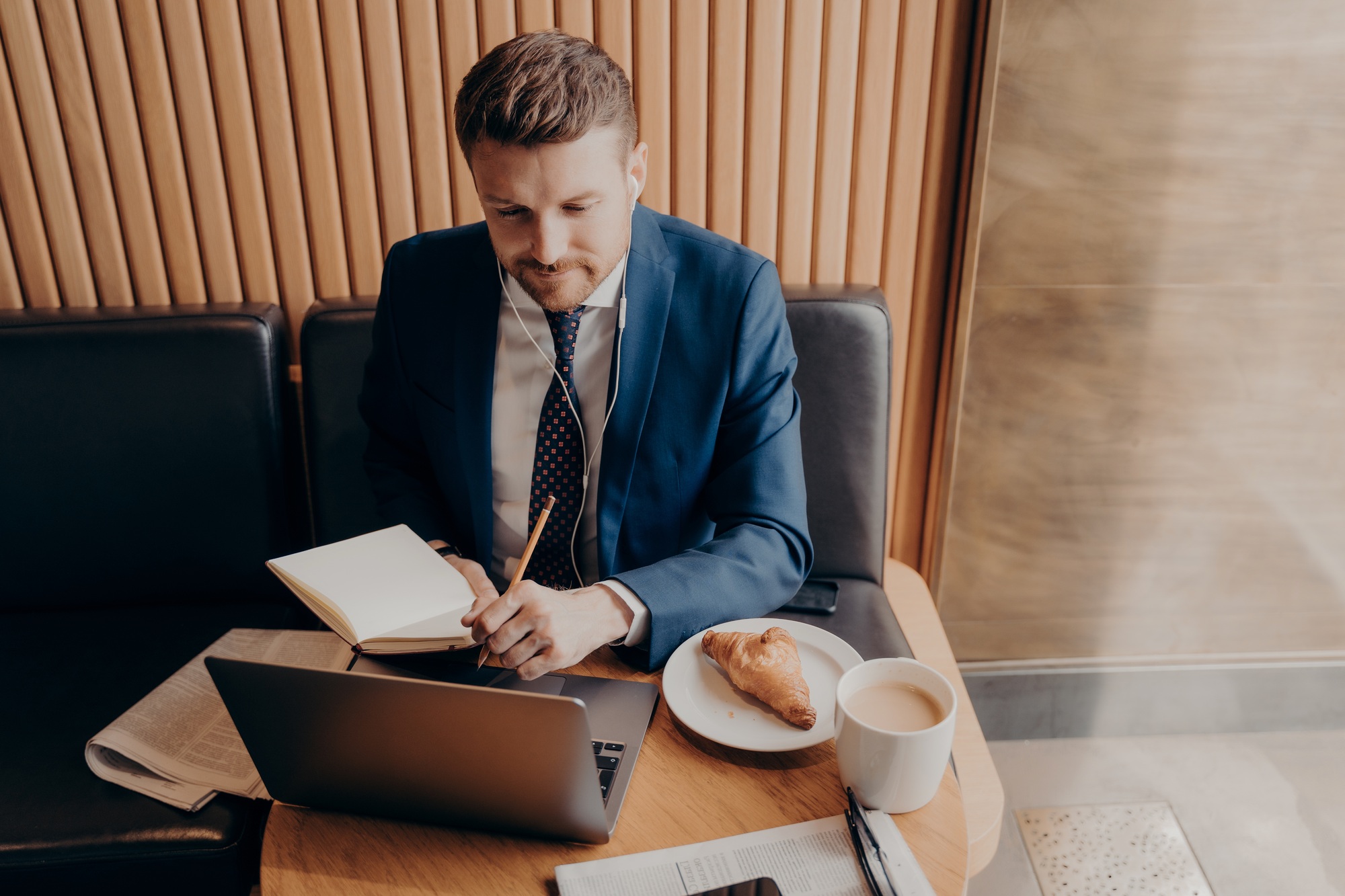 Male business executive watching webinar on laptop in restaurant